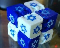 A photo of a fidget cube made of smaller cubes, each one being either white or blue with a six-pointed star on it.